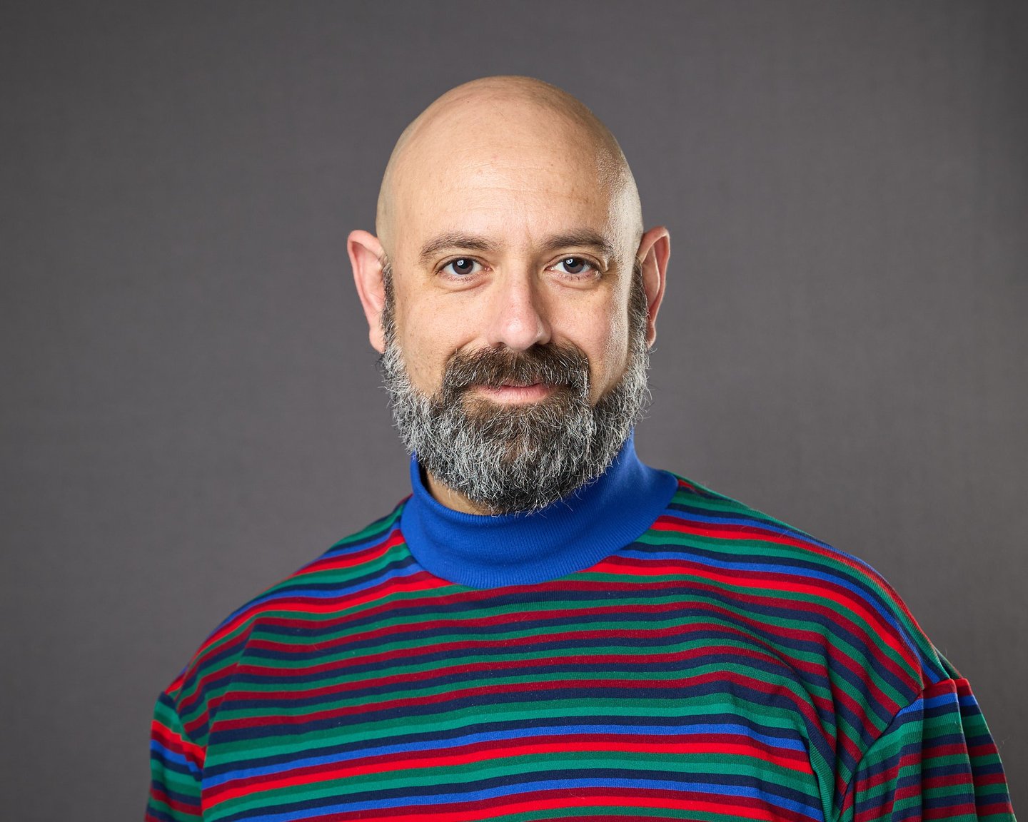 bald psychologist in striped shirt who provides therapy trauma LGBTQIA+ 