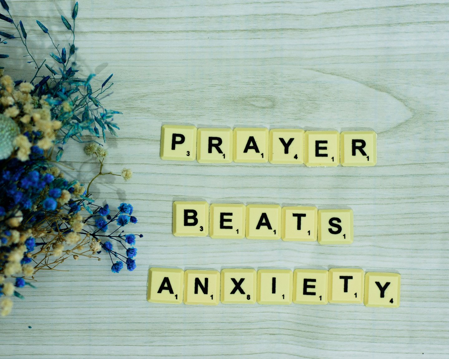 Scrabble letters spell out "prayer beats anxiety", a common misguided belief in religious circles