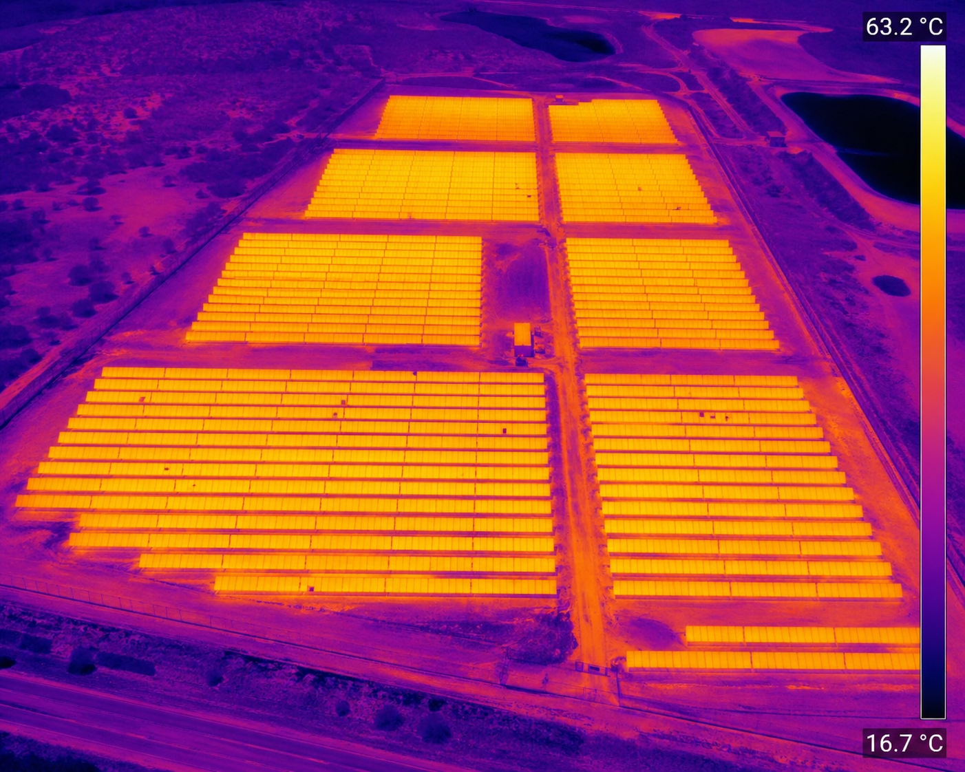 Aerial thermal imaging scan of a large solar farm showing heat distribution across solar panel arrays.