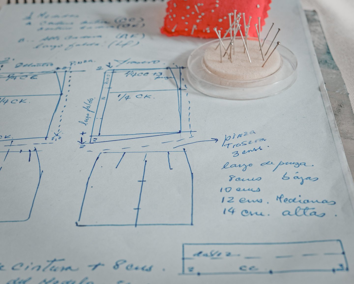 Hoja con un patrón de costura hecho a mano, dibujado con bolígrafo azul, mostrando medidas y detalle