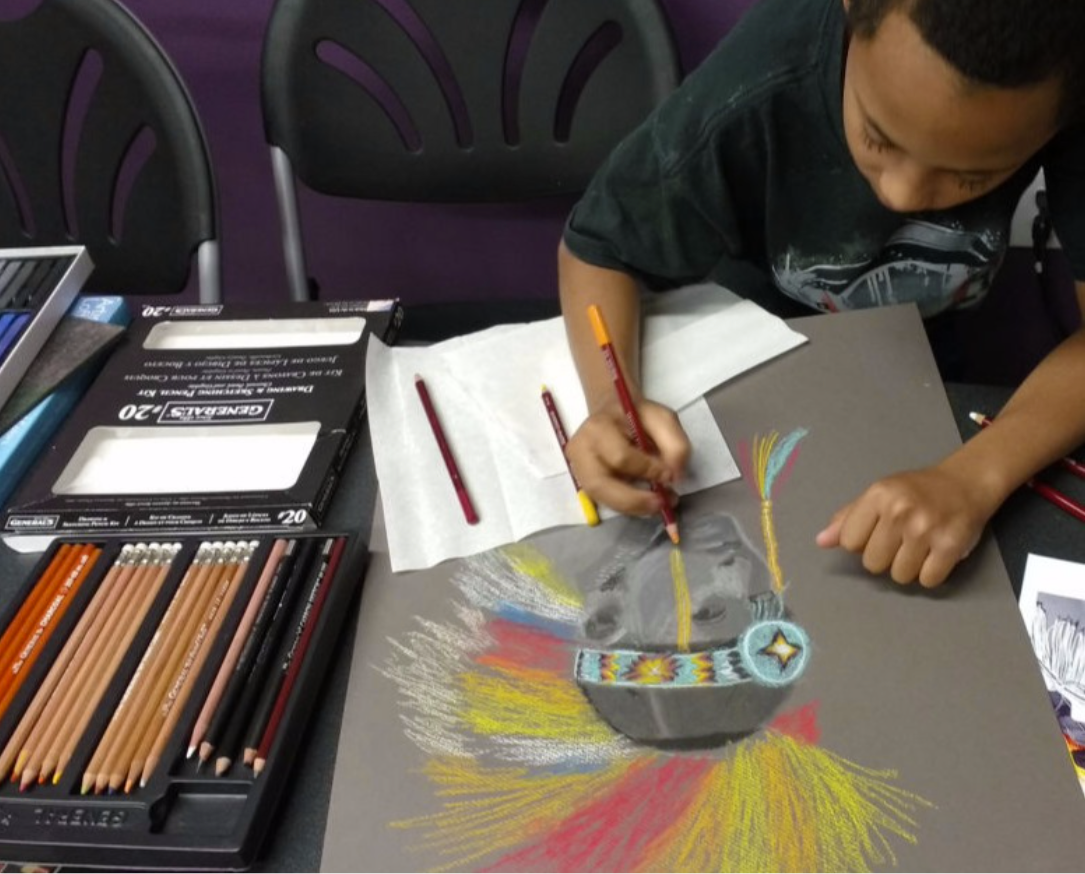 a young boy is drawing a colorful picture of a native american