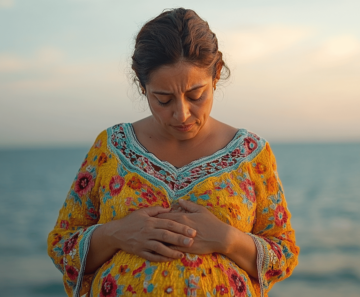 Mujer tocándose el pecho y viendo hacia el suelo con un fondo de mar 
