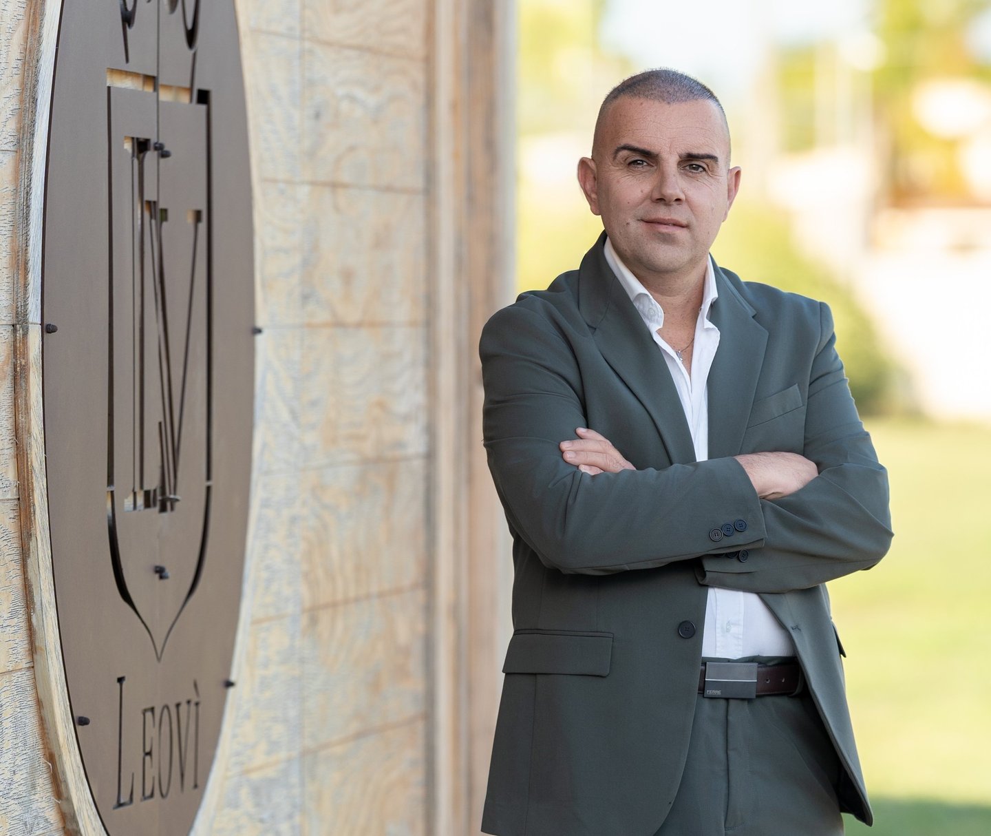 a man in a suit and white shirt standing in front of a clock