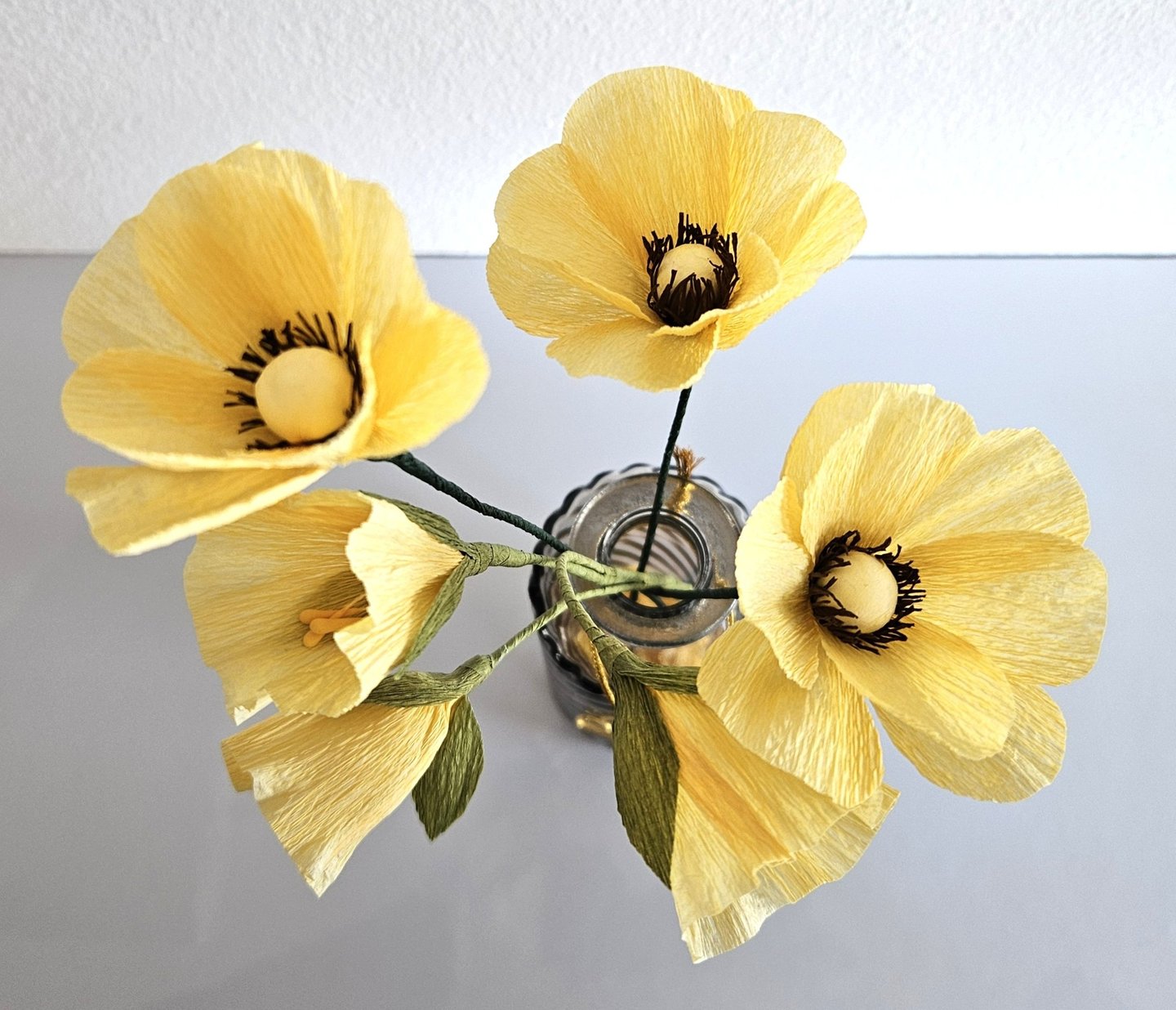 Dit boeketje is gemaakt van crepe papier en bestaat uit verschillende gele bloemetjes. Samen vormen ze een mooi geheel.