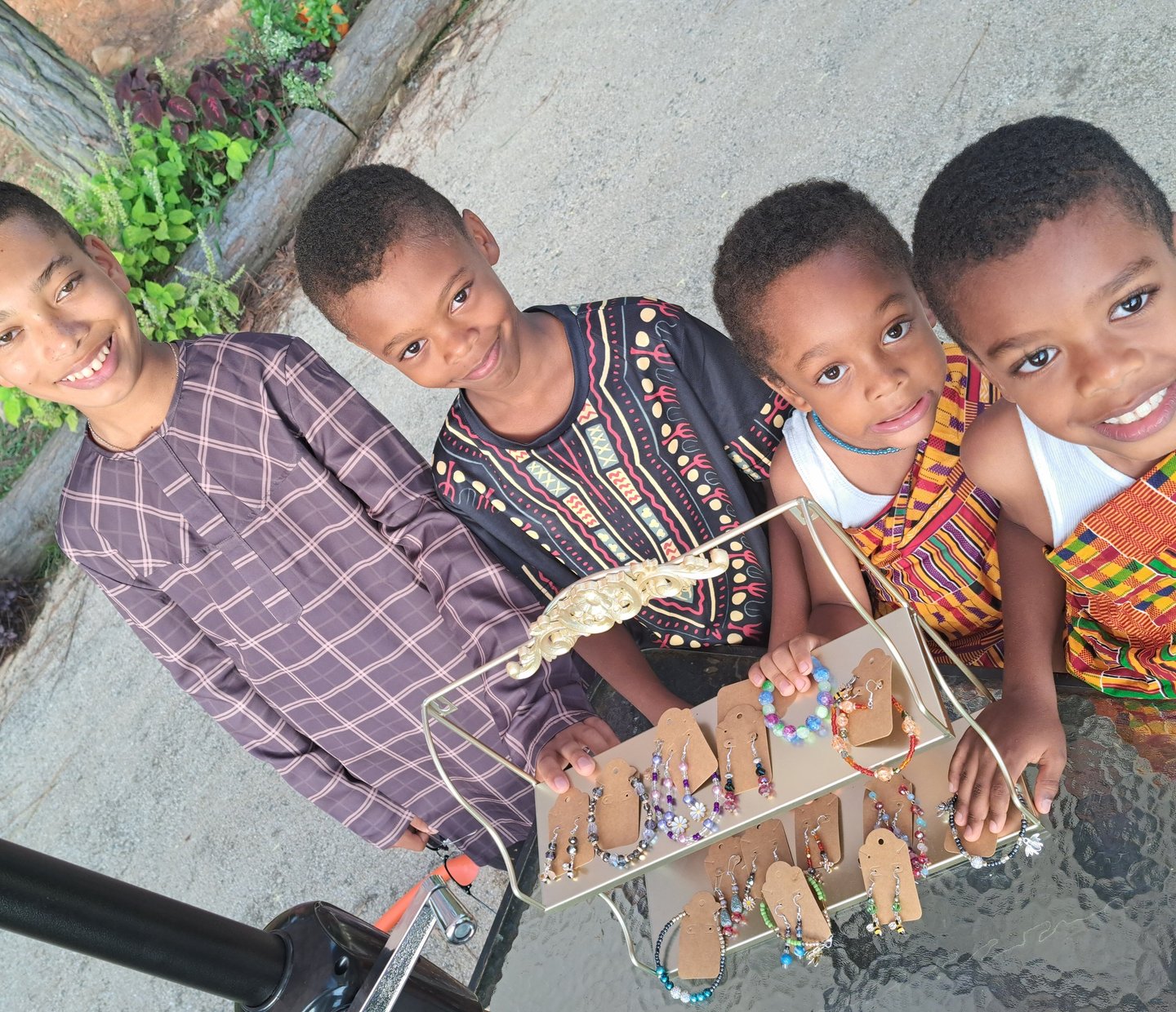 Picture of Four Brothers next to the jewelry they created left to right Ethan, Decklan, Theodore and Mason.