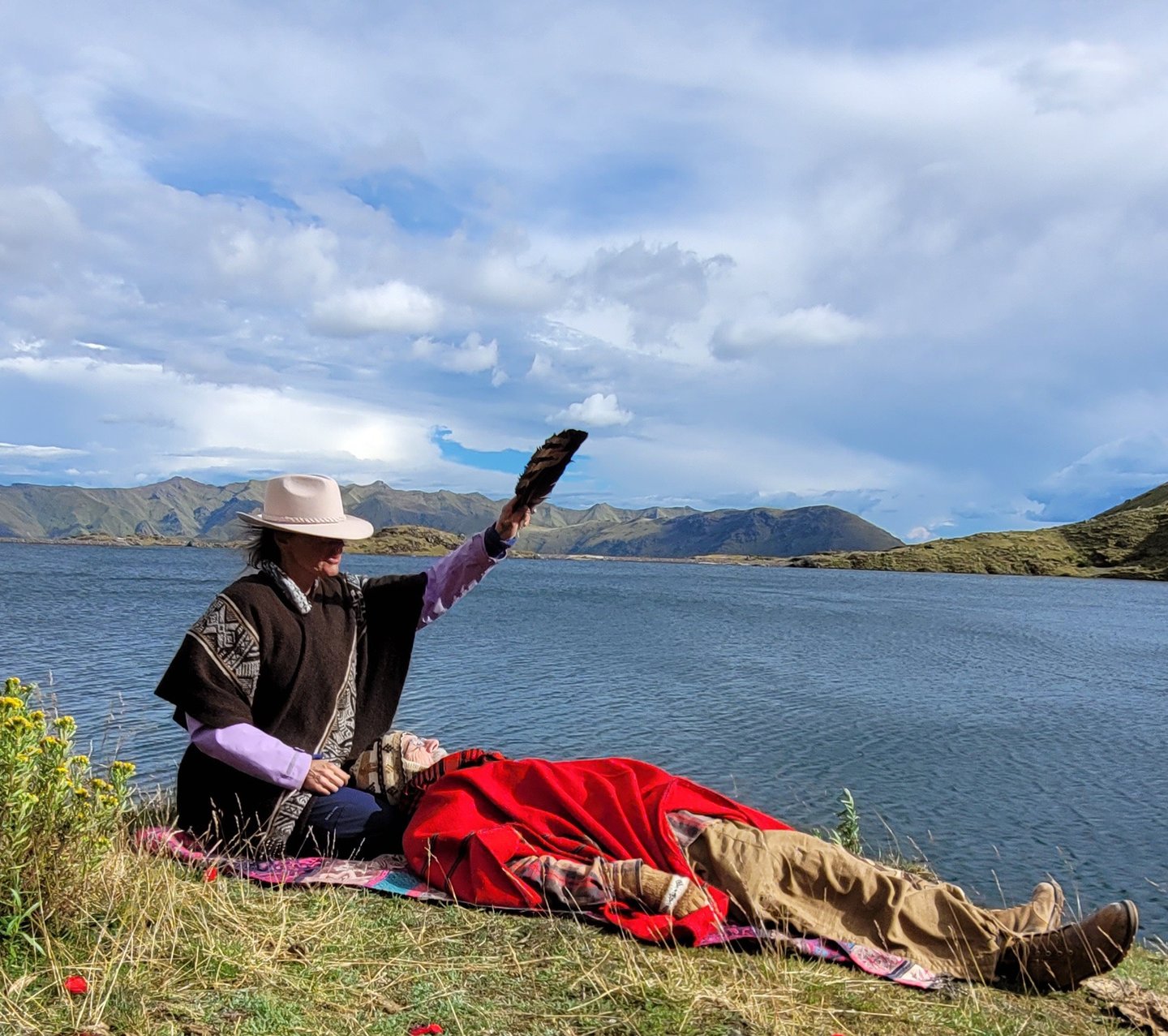 schamanische Behandlung eine Frau behandelt einen Mann in den Bergen an einem See