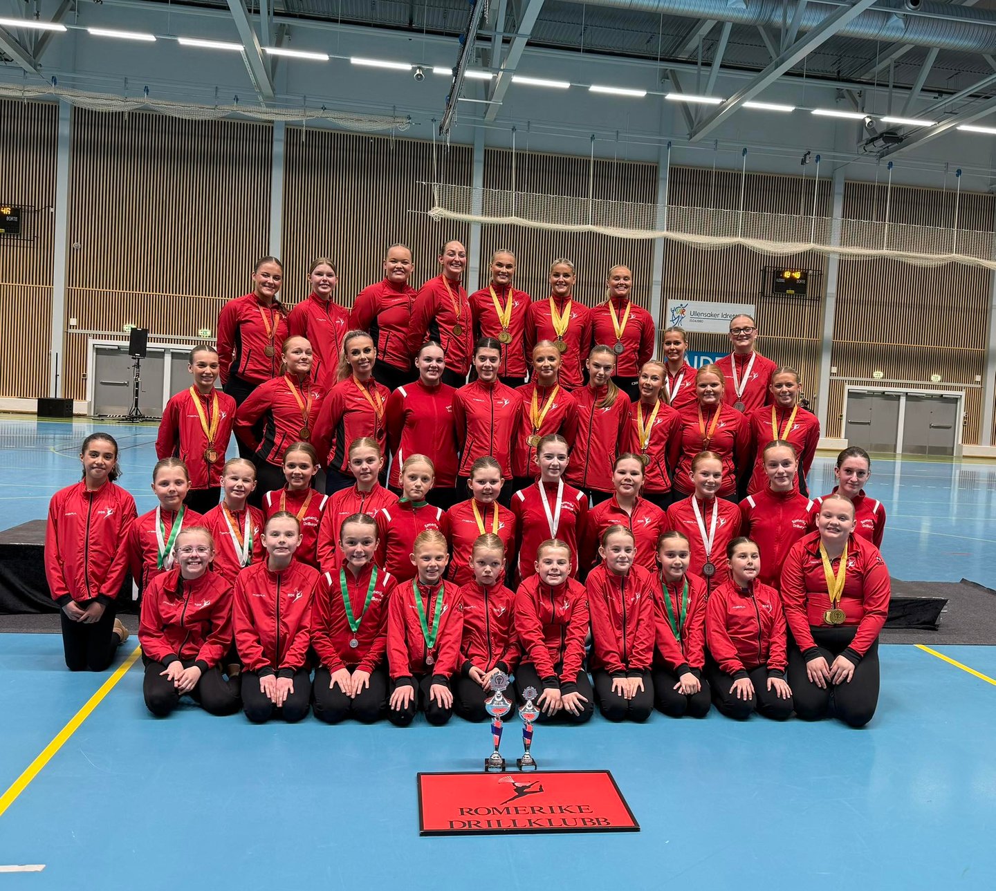 a group of people standing around a trophy, after baton/twirling competition