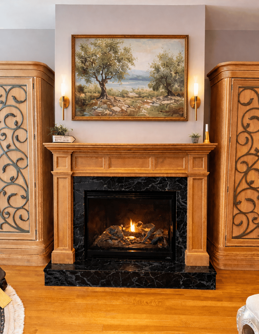 Custom stained wood fireplace mantel with black marble surround and decorative built-in cabinetry in