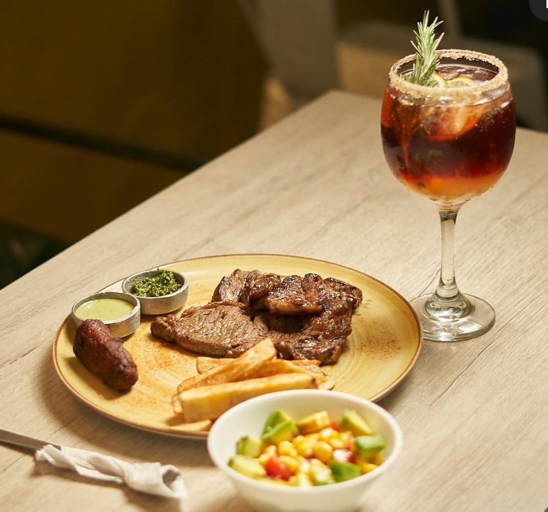 Delicosa carne con papas fritas ensalada y vino en Kabú Café Restaurante Calarcá Quindío