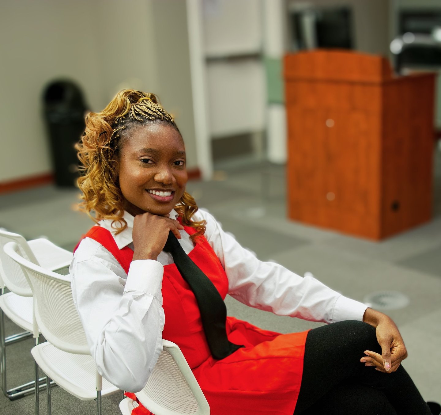 Iheoma Uzomba Oma is Loud Professional headshot in red and white