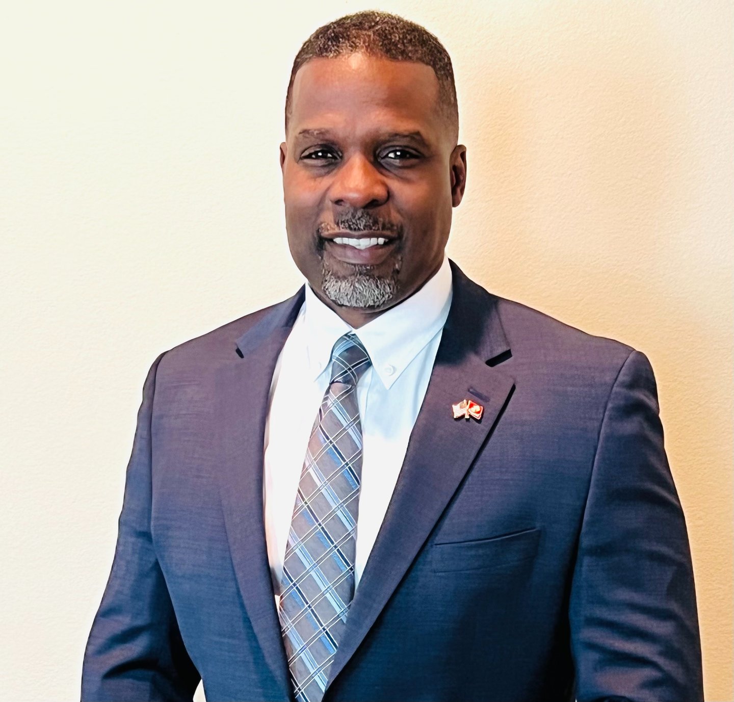 Dr. Marlon Ware professional headshot in blue suit with blue striped tie