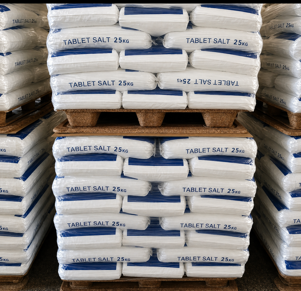 Pallets of 25kg bags of water softener tablet salt stacked in a warehouse.