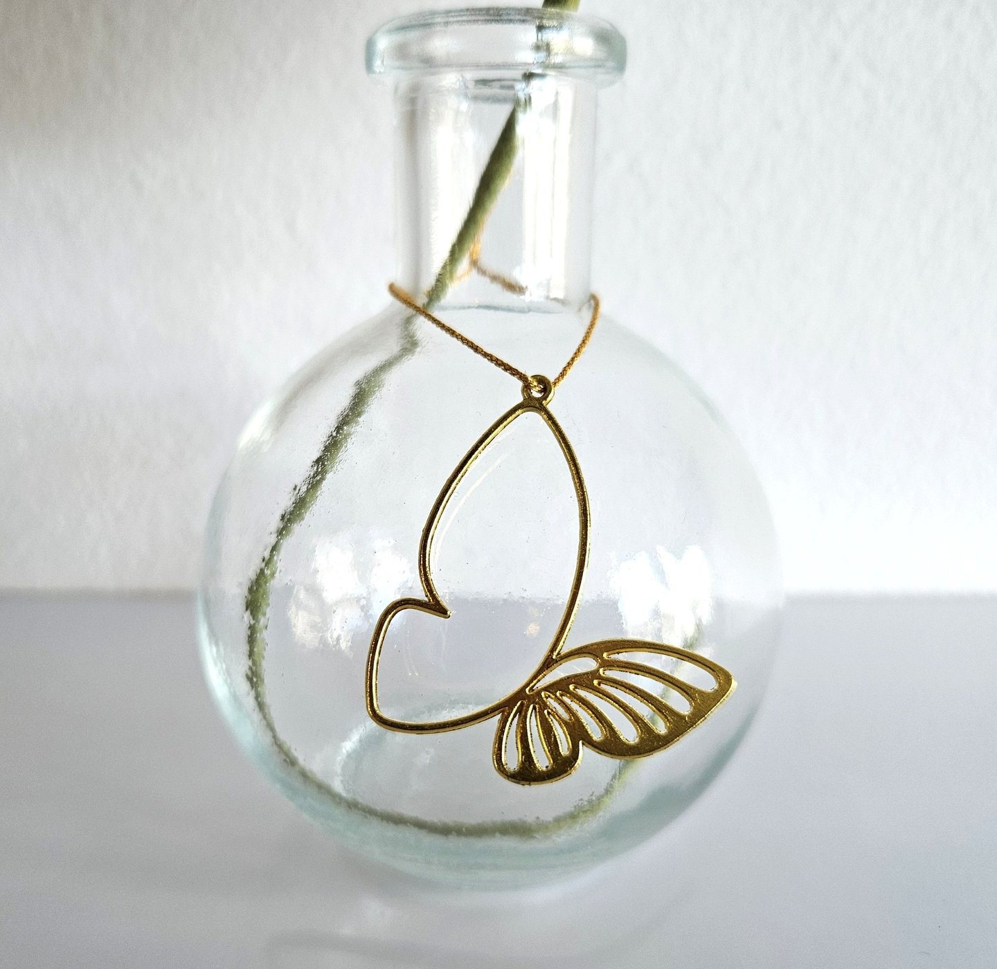 Dit vaasje is afgewerkt met een gouden bedeltje van een vlinder. Een mooie toevoeging aan een papieren bloem of bloemen.