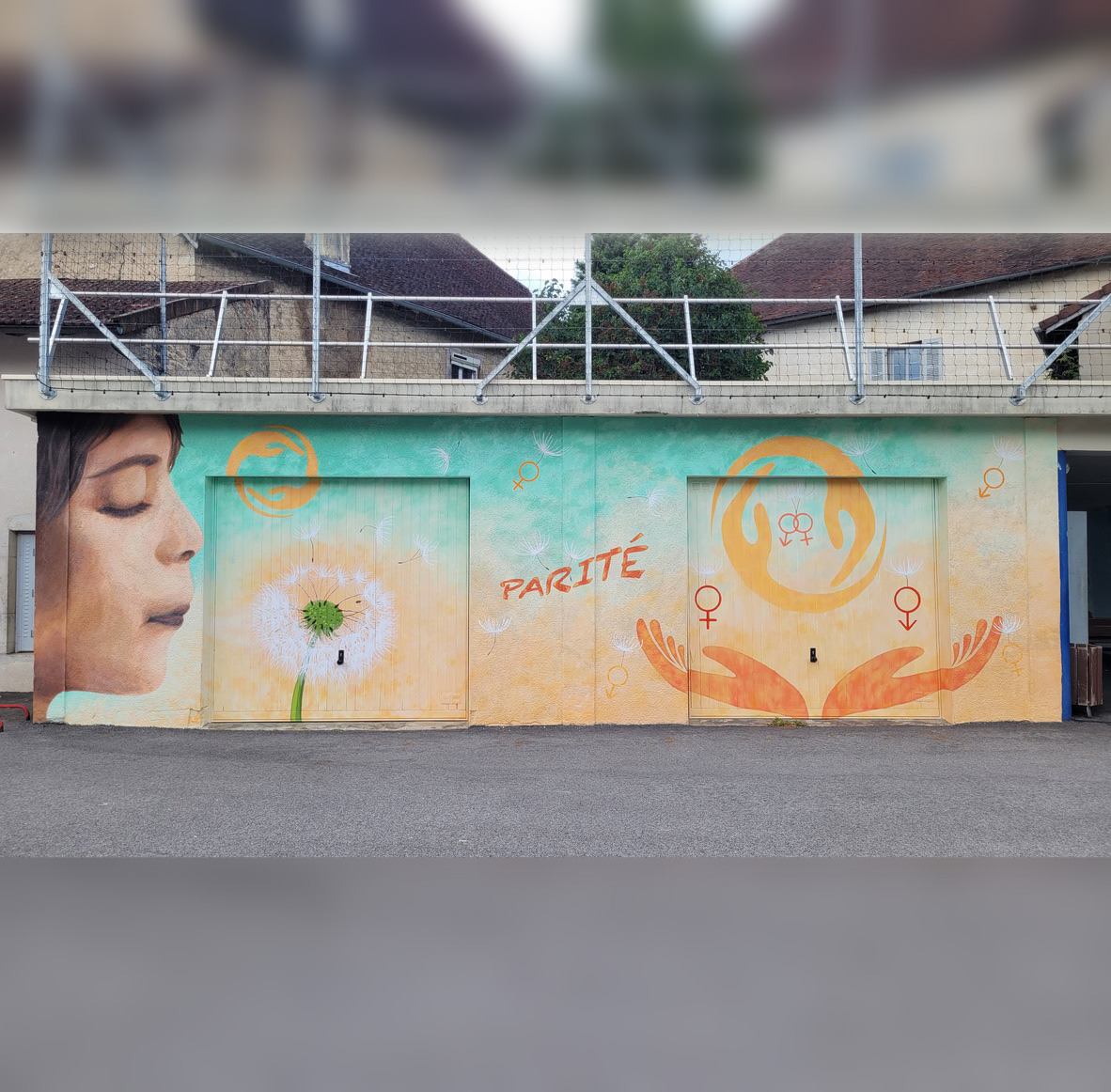 Fresque colorée peinte sur mur extérieur dans une cour de collège