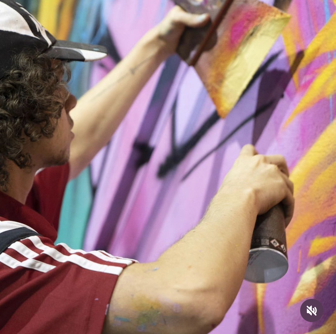 un homme avec une casquette entrain de peindre un graff