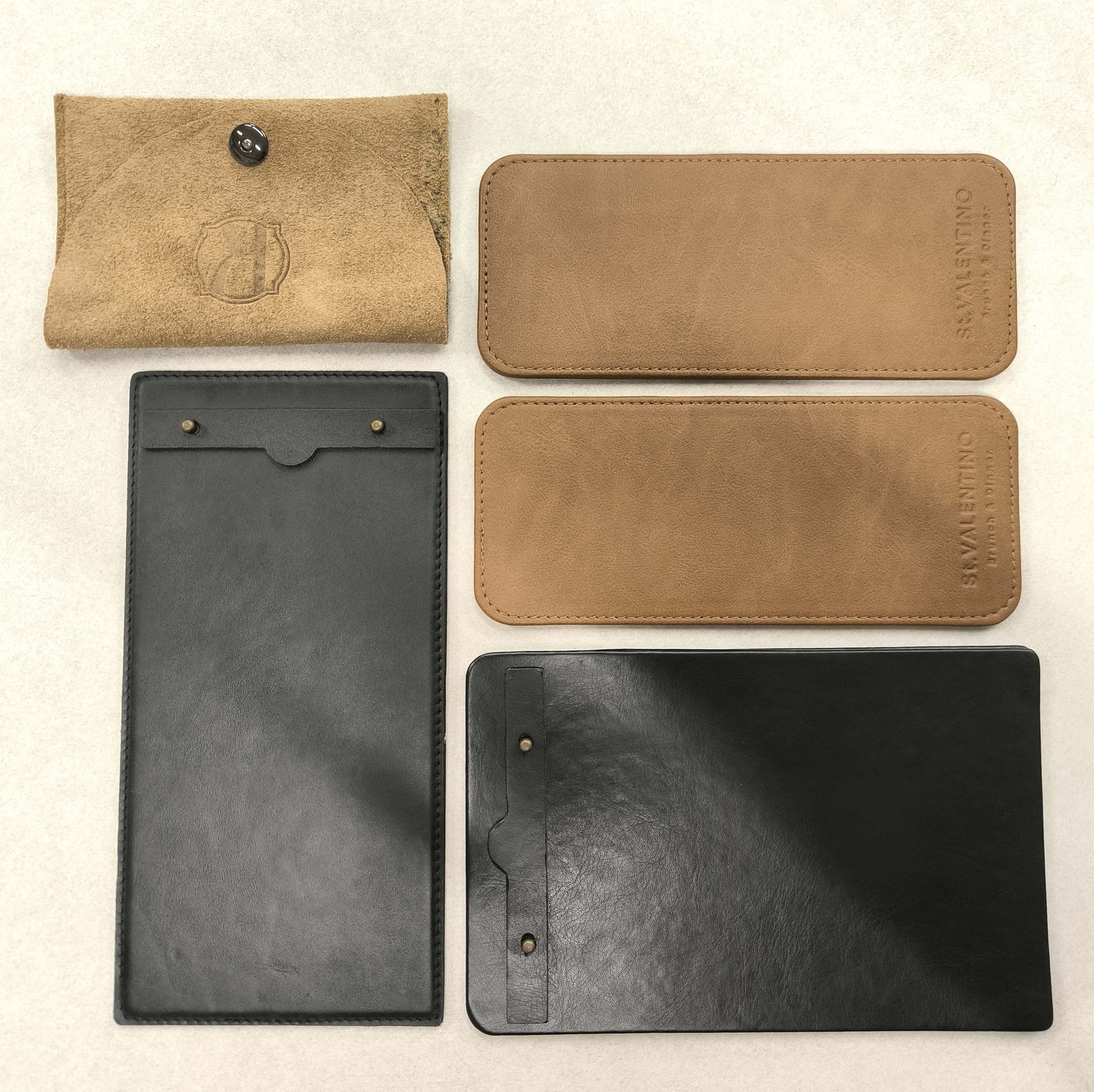 Handcrafted leather and suede menu covers and bill folders in black and tan for restaurant tabletop accessories.