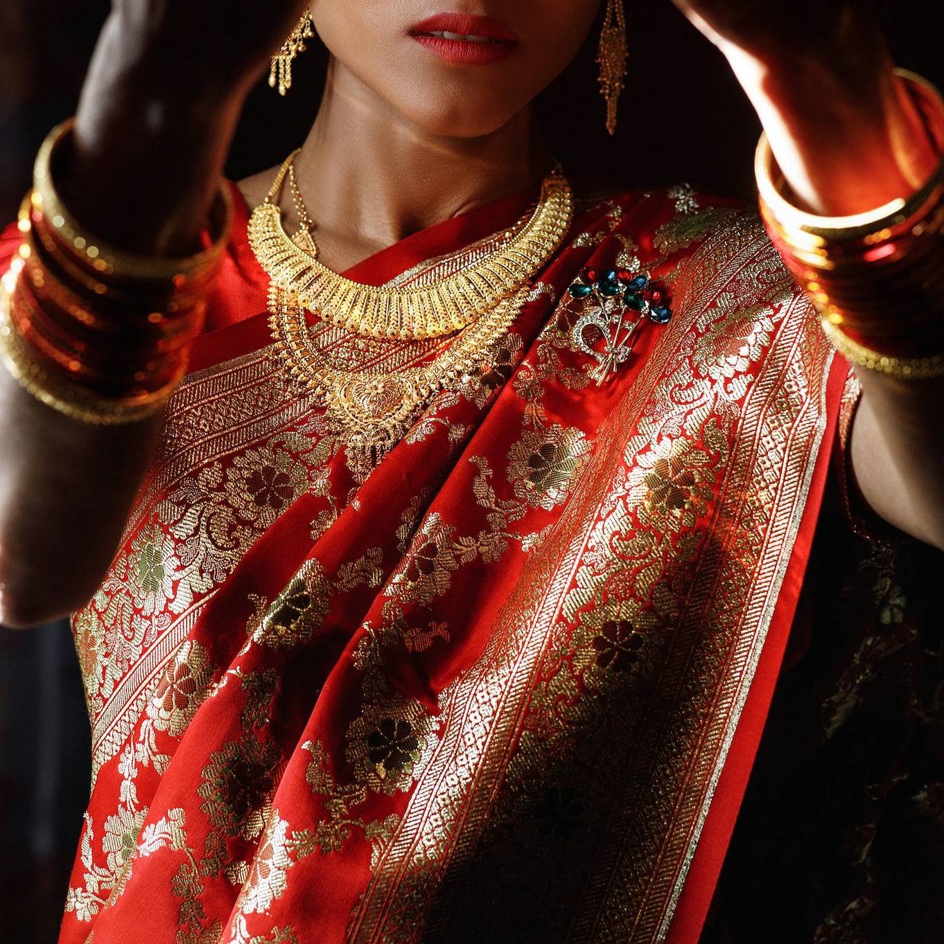 a woman in a red sari gold jewelry temple jewellery