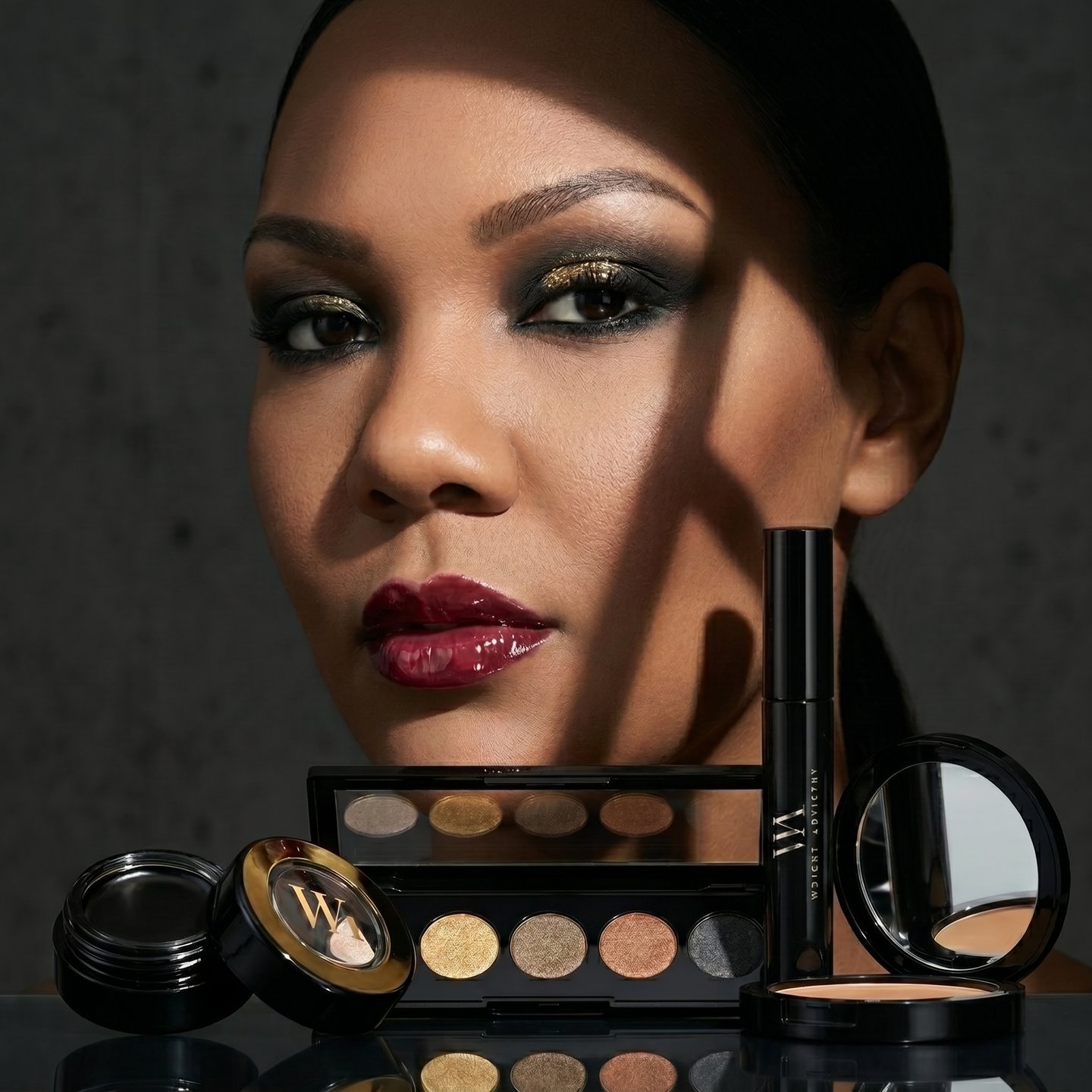 A woman wearing smoky gold eyeshadow and red lipstick next to luxury cosmetics.