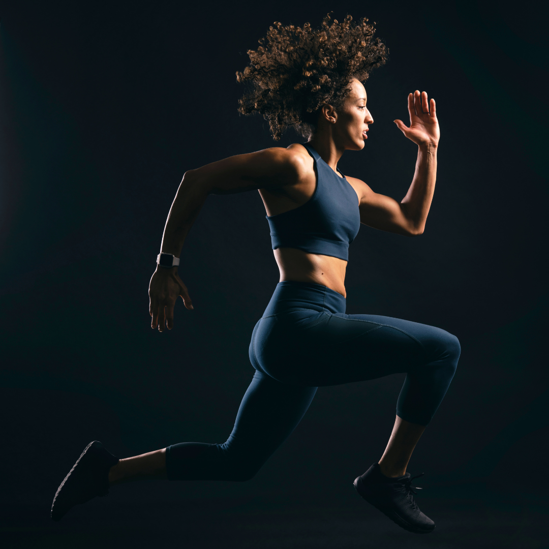 a woman in a sports bra top running in the dark