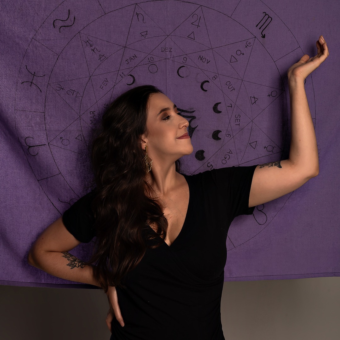 mulher sorrindo com mapa astral ao fundo