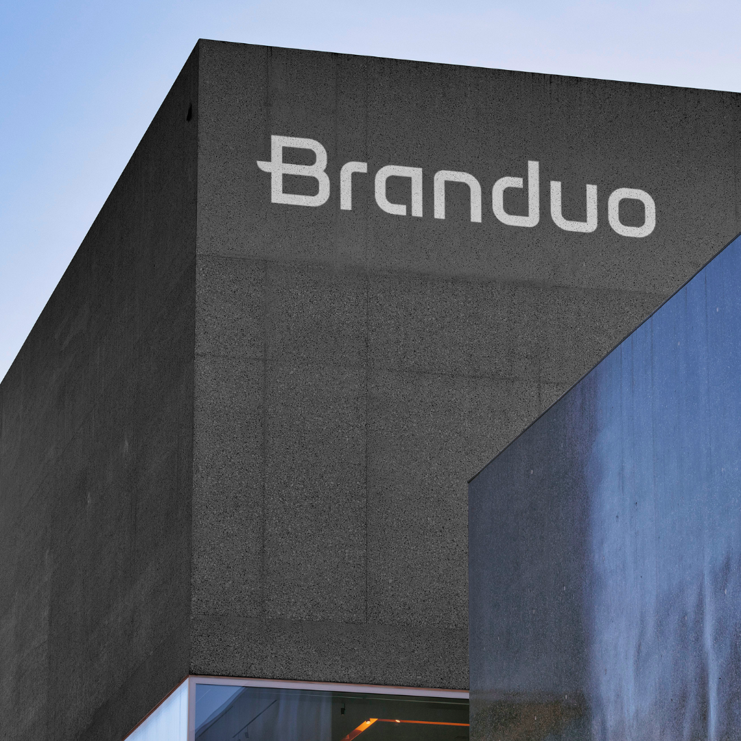 Fachada do Estúdio Criativo Branduo, com textura de cimento cinza escuro e letreiro em branco.
