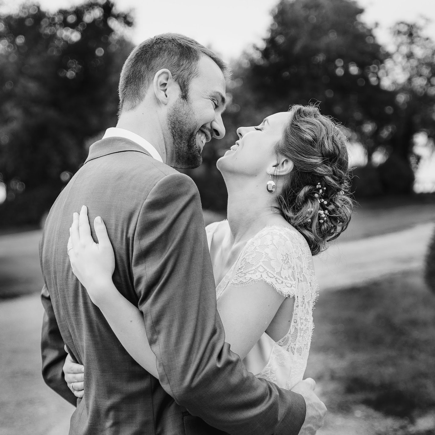 une mariée et un marié s'embrassant dans un champ