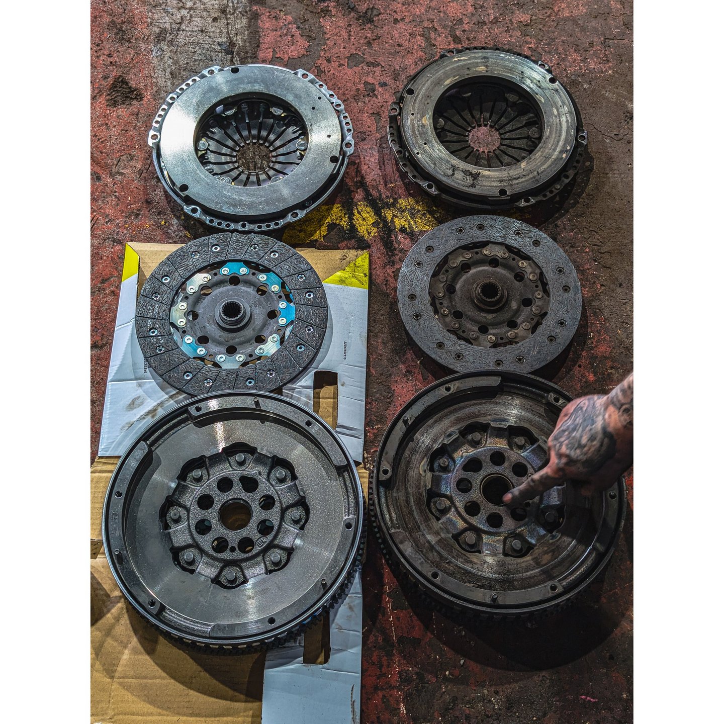 Comparison of new and old car clutch kits including pressure plates, friction discs, and flywheels.