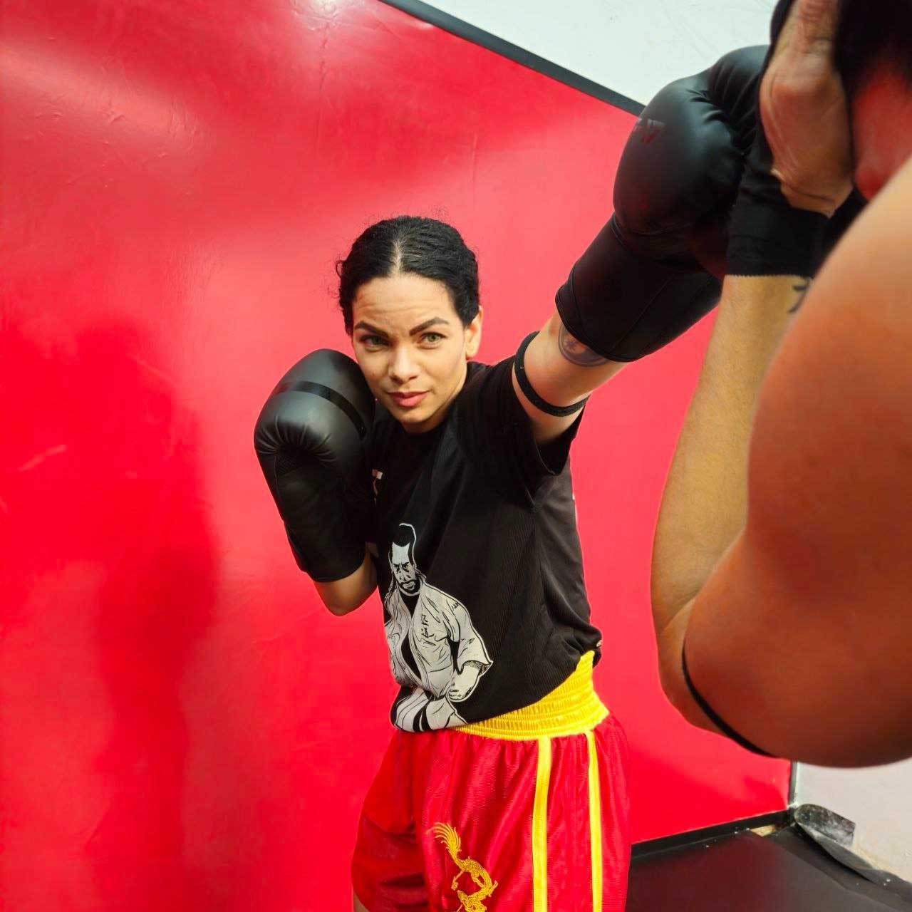 a woman in a boxing gloves is posing for a picture
