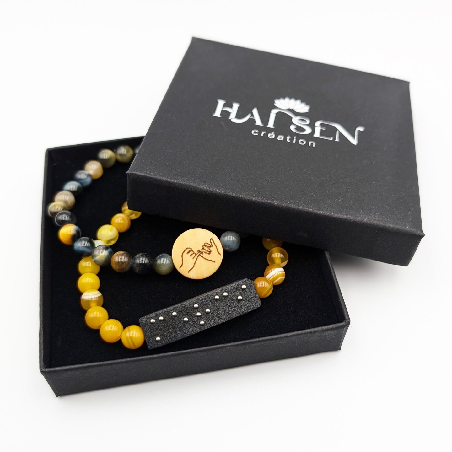2 Bracelets un avec plaque braille Merci et un avec un cabochon avec le symbole amitié.