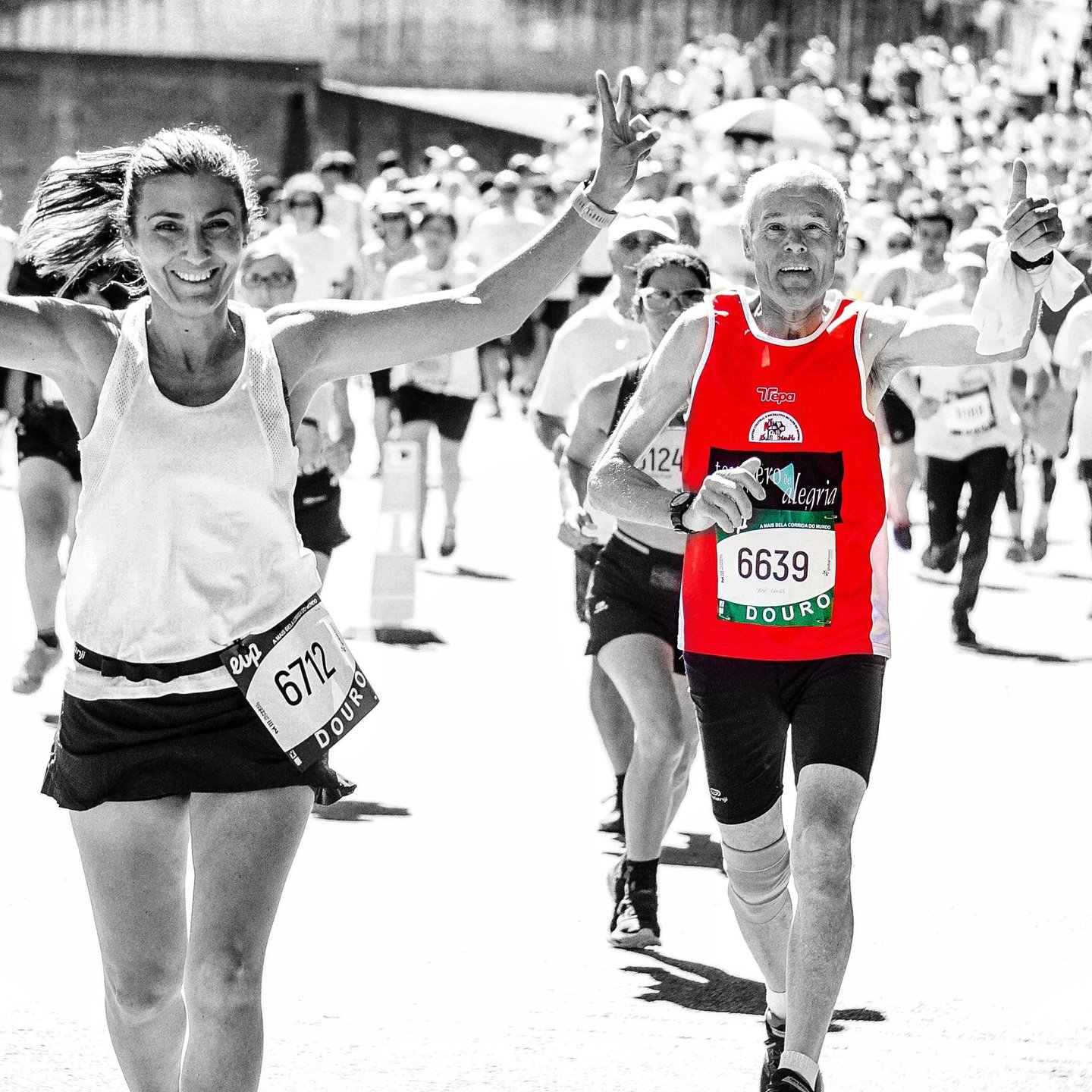 a woman and an old man running in a marathon race