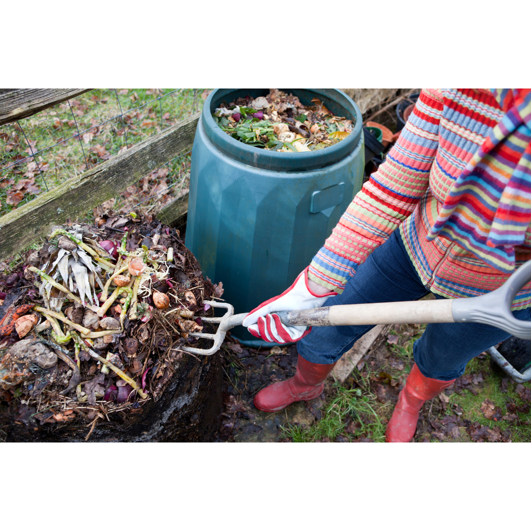 a woman turning over the compost pile
