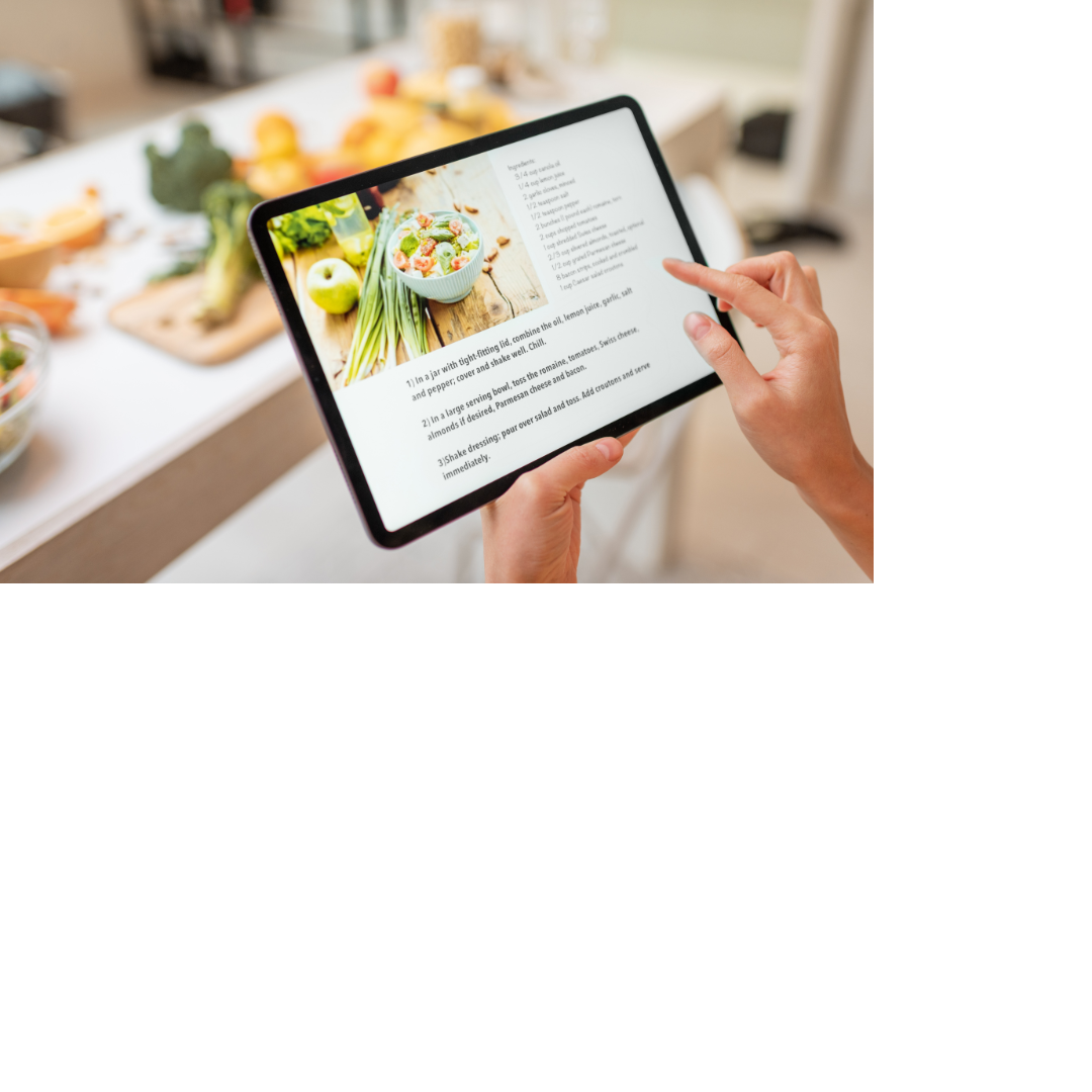 Person using a tablet to display a recipe. Ingredients are blurred out in the background