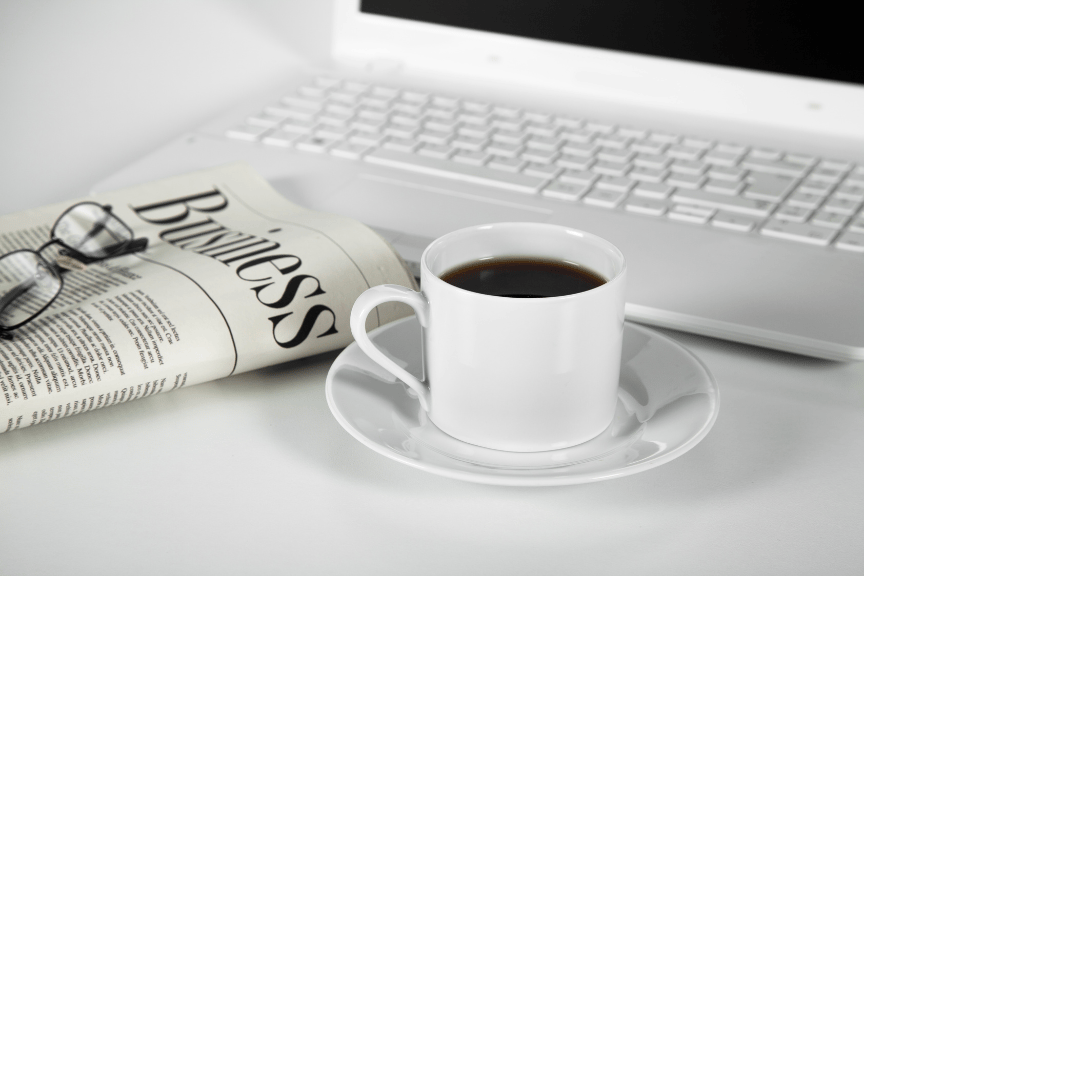 Pic of a folded newspaper with glasses on top, a mug of coffee, and a laptop