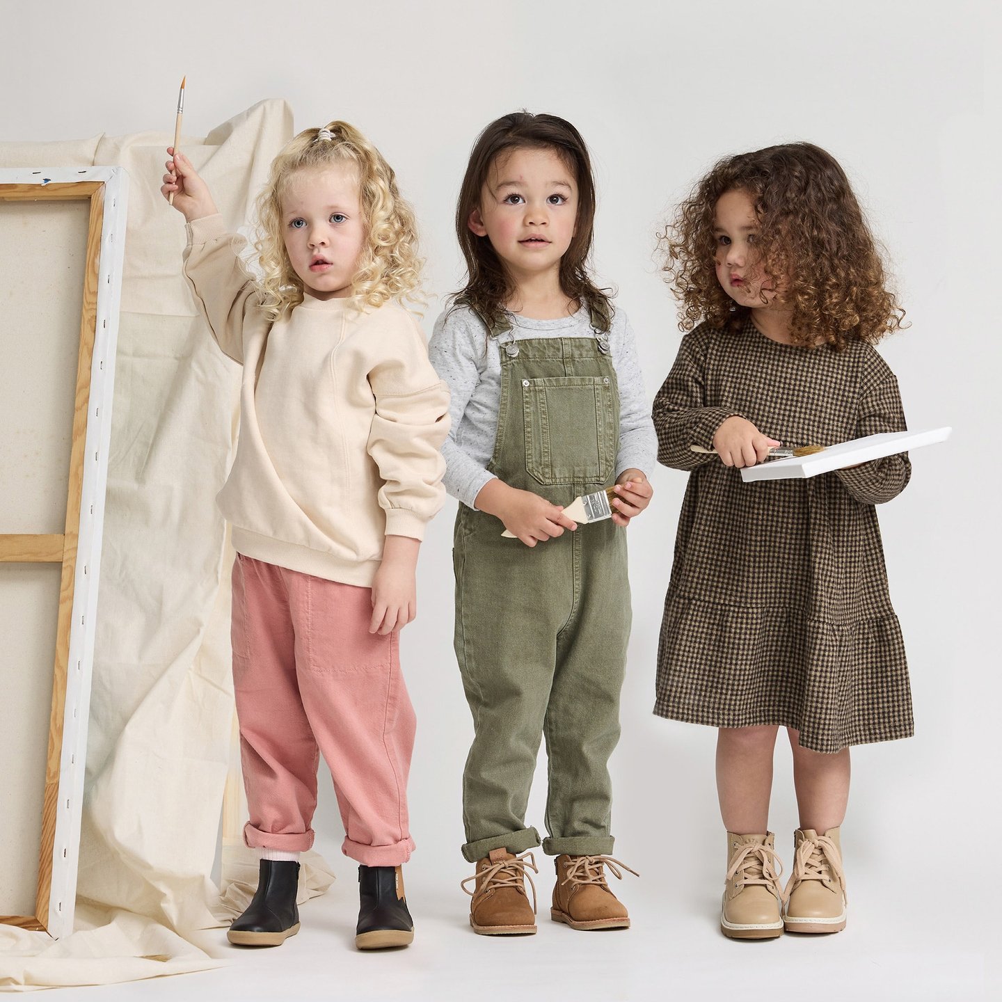 Fashion campaign photography - three young children standing in front of a white canvas
