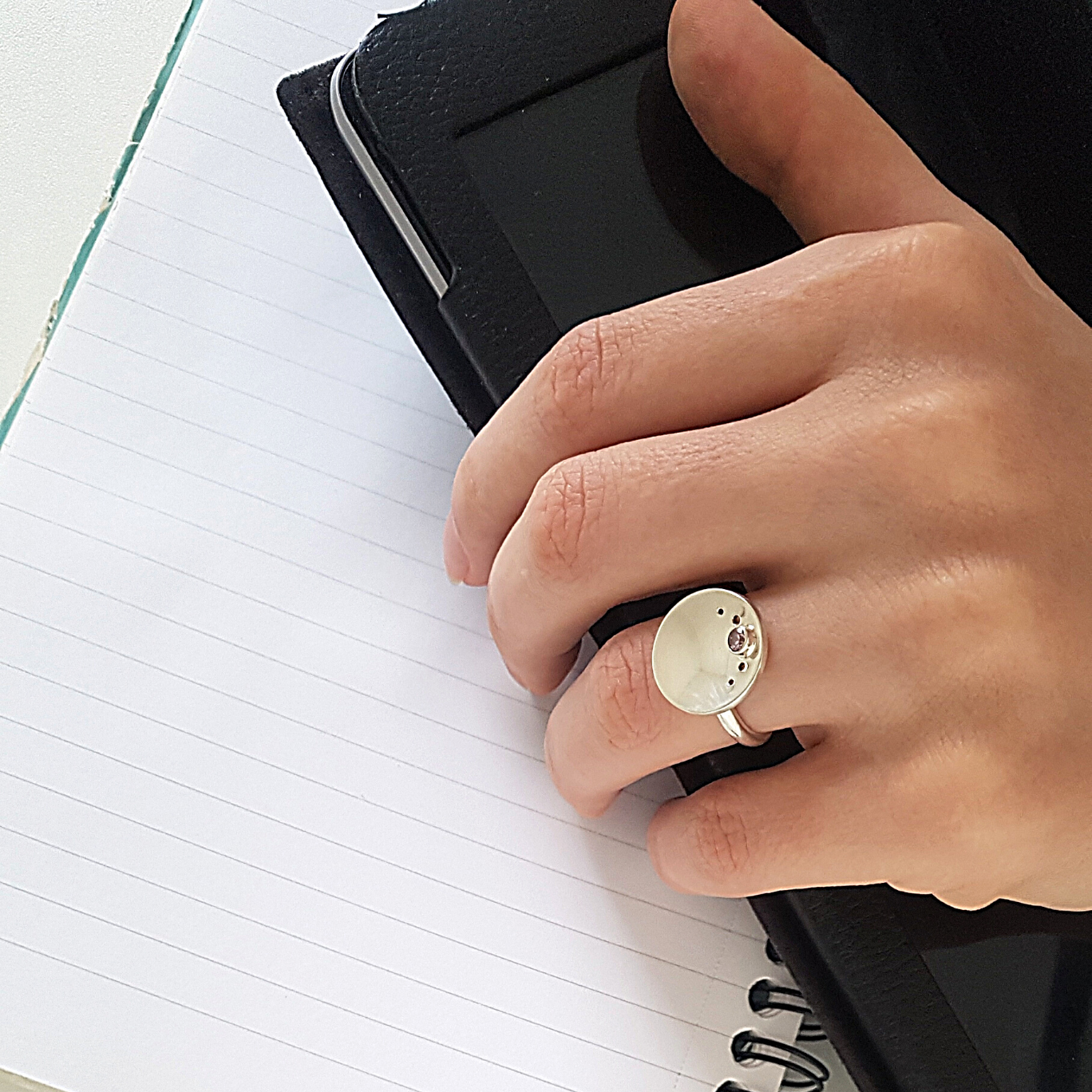 a person's hand holding a ring with a ring on it