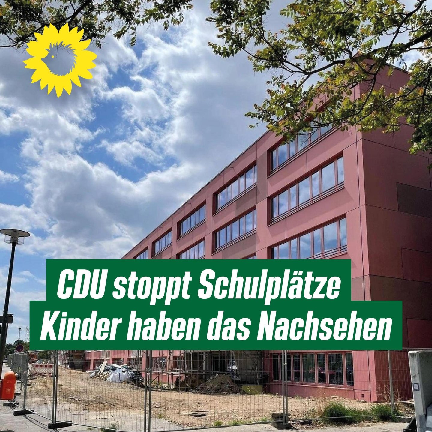 Sharepic mit dem Foto einer Schule im Bau, mit Bauzäunen davor.