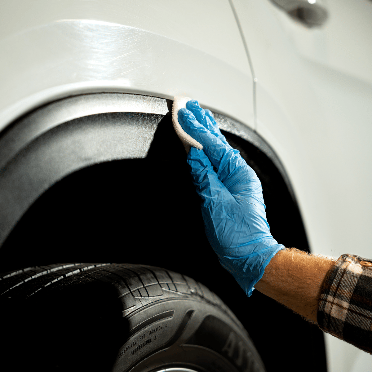 Professional car detailing applying plastic trim restorer to a white vehicle in Logan Ohio 