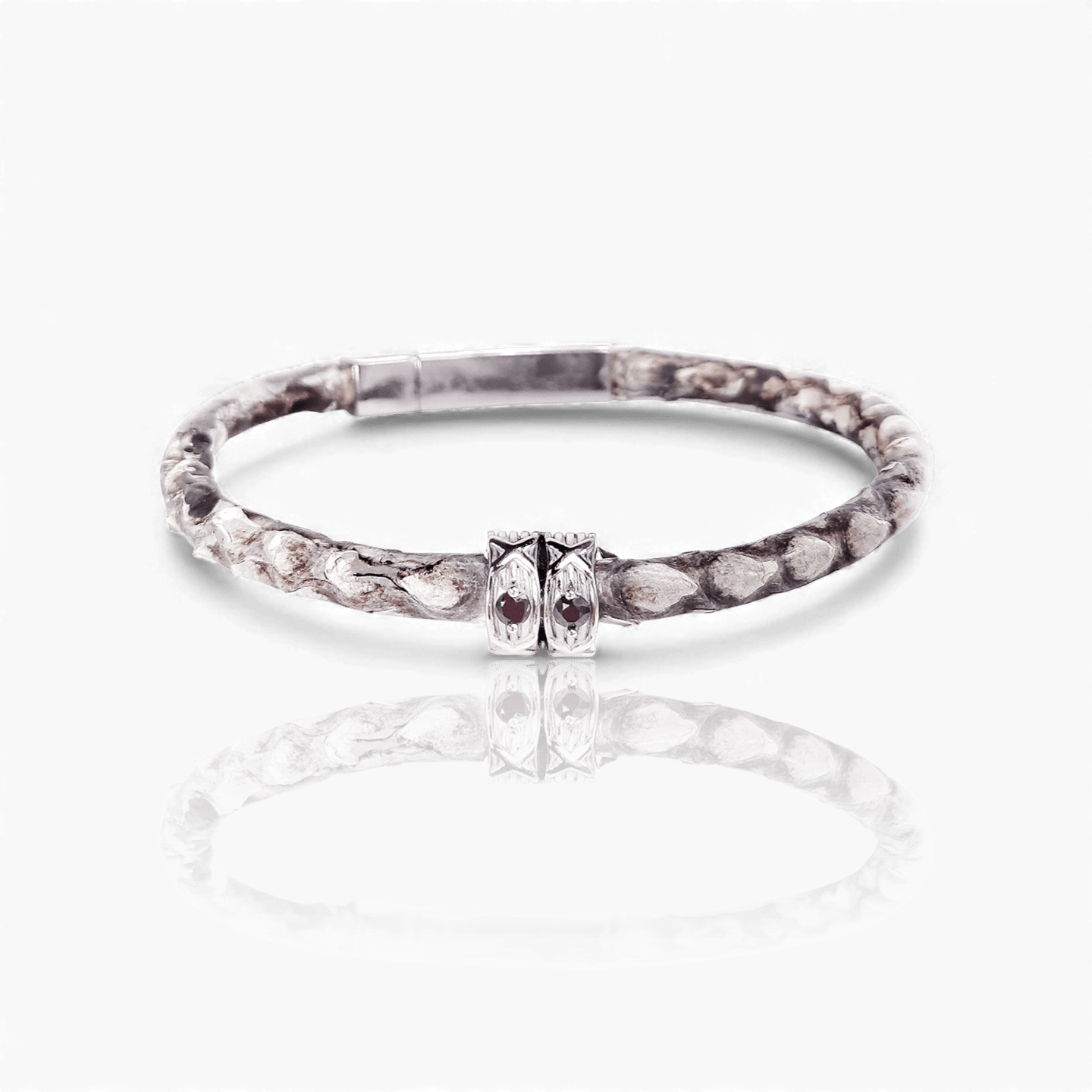 Handcrafted python skin leather bracelet with silver details and garnet gemstones on a white background.