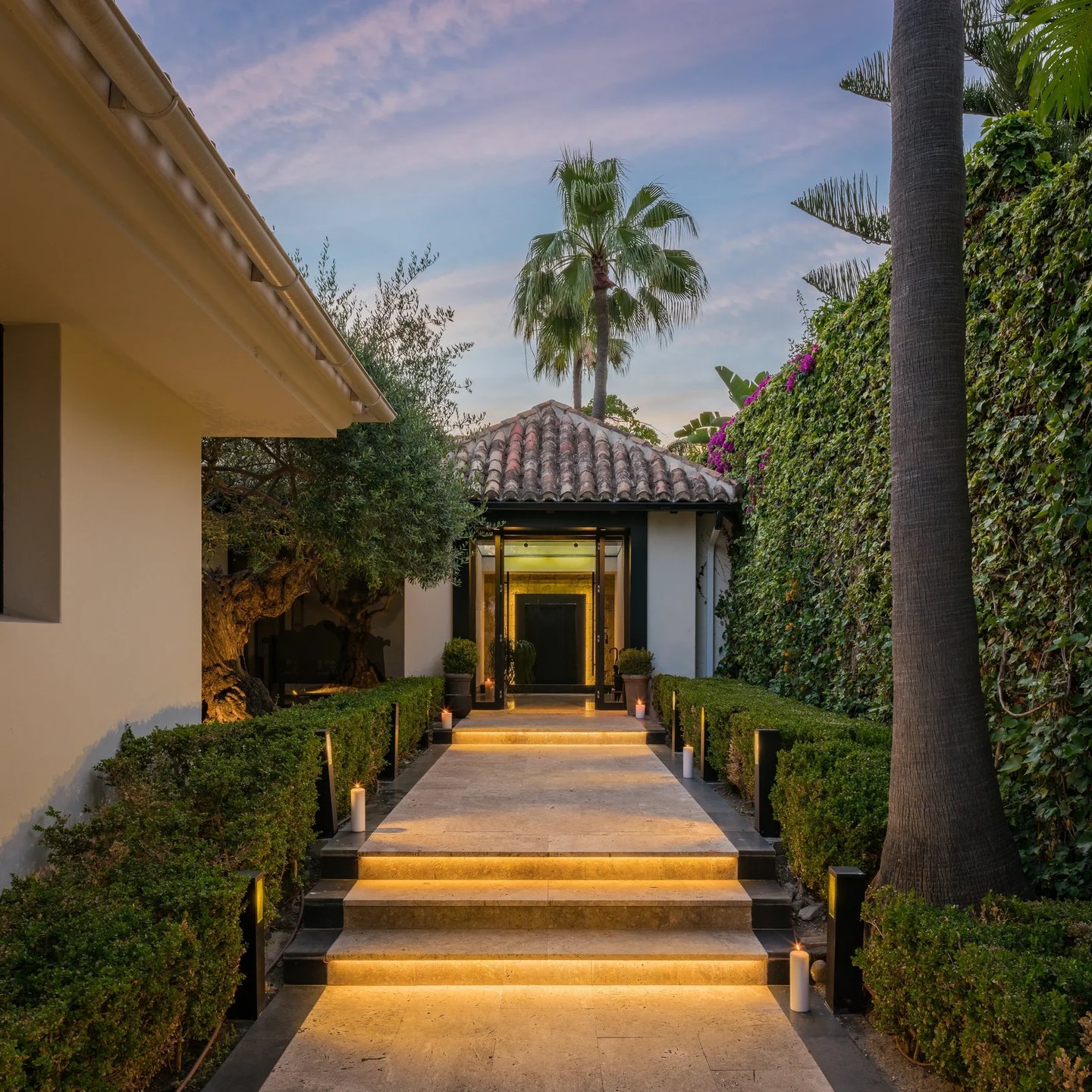 Illuminated villa entrance with stone steps