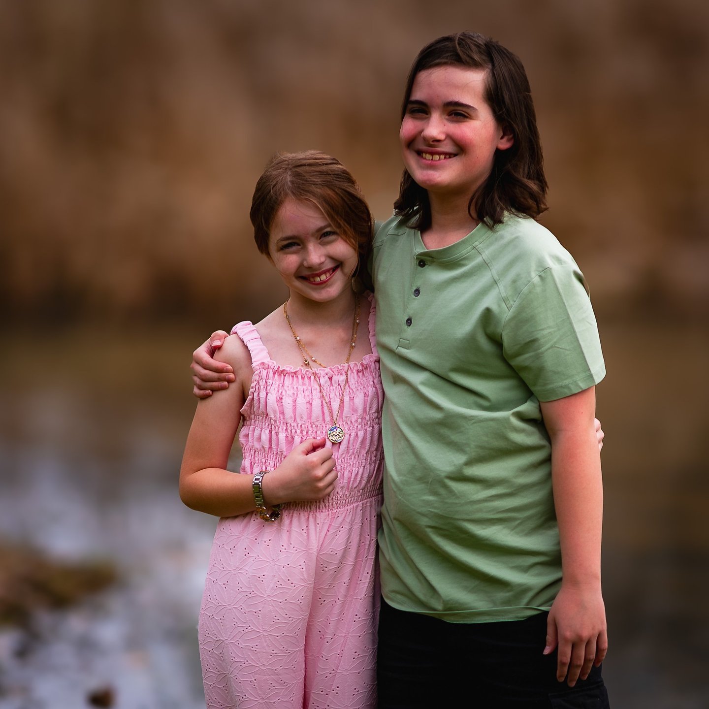 Two happy siblings smiling together outdoors, one wearing a pink jumpsuit, Athens, Ohio Burr Oak 