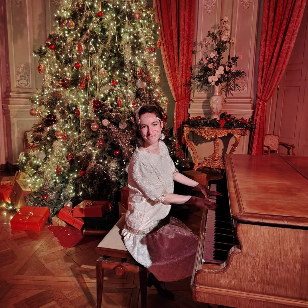 chanteuse pianiste en tenue belle époque dans un décor de noël dans un chateau