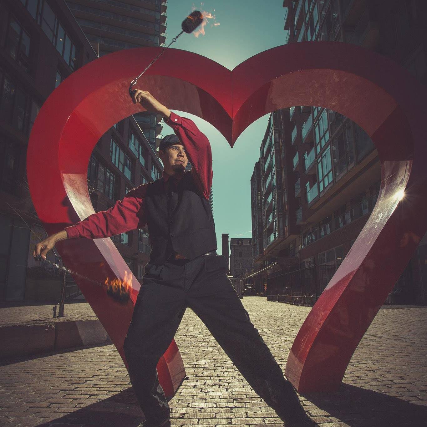 Fire poi dancer in front of heart