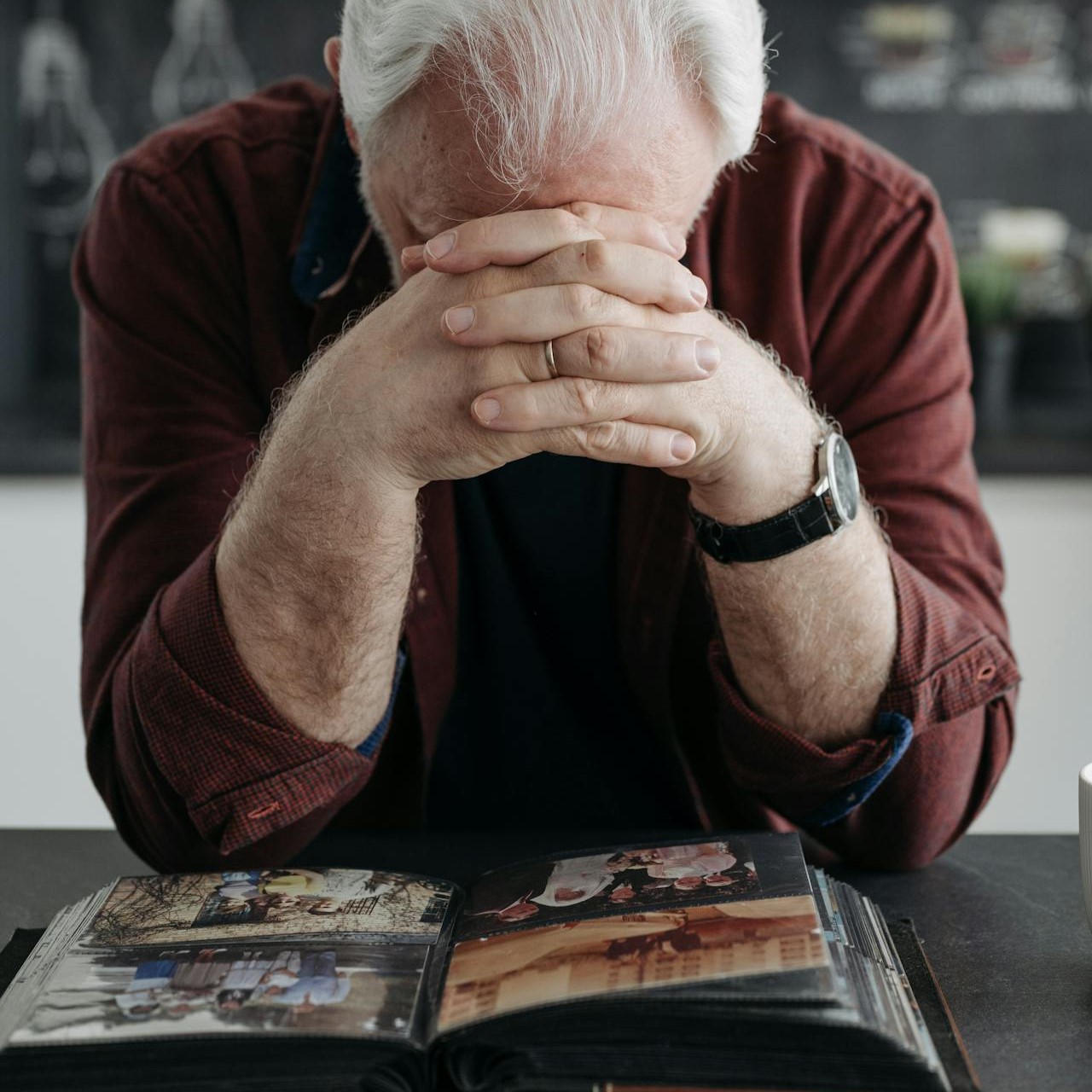 a man with elbows on table and head down