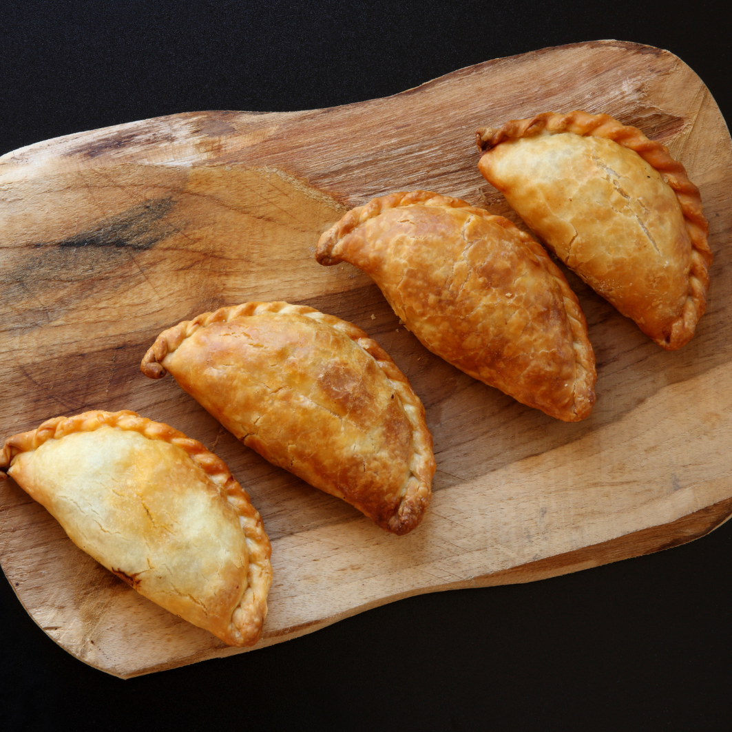 a wooden cutting board with three pastries on a cutting board