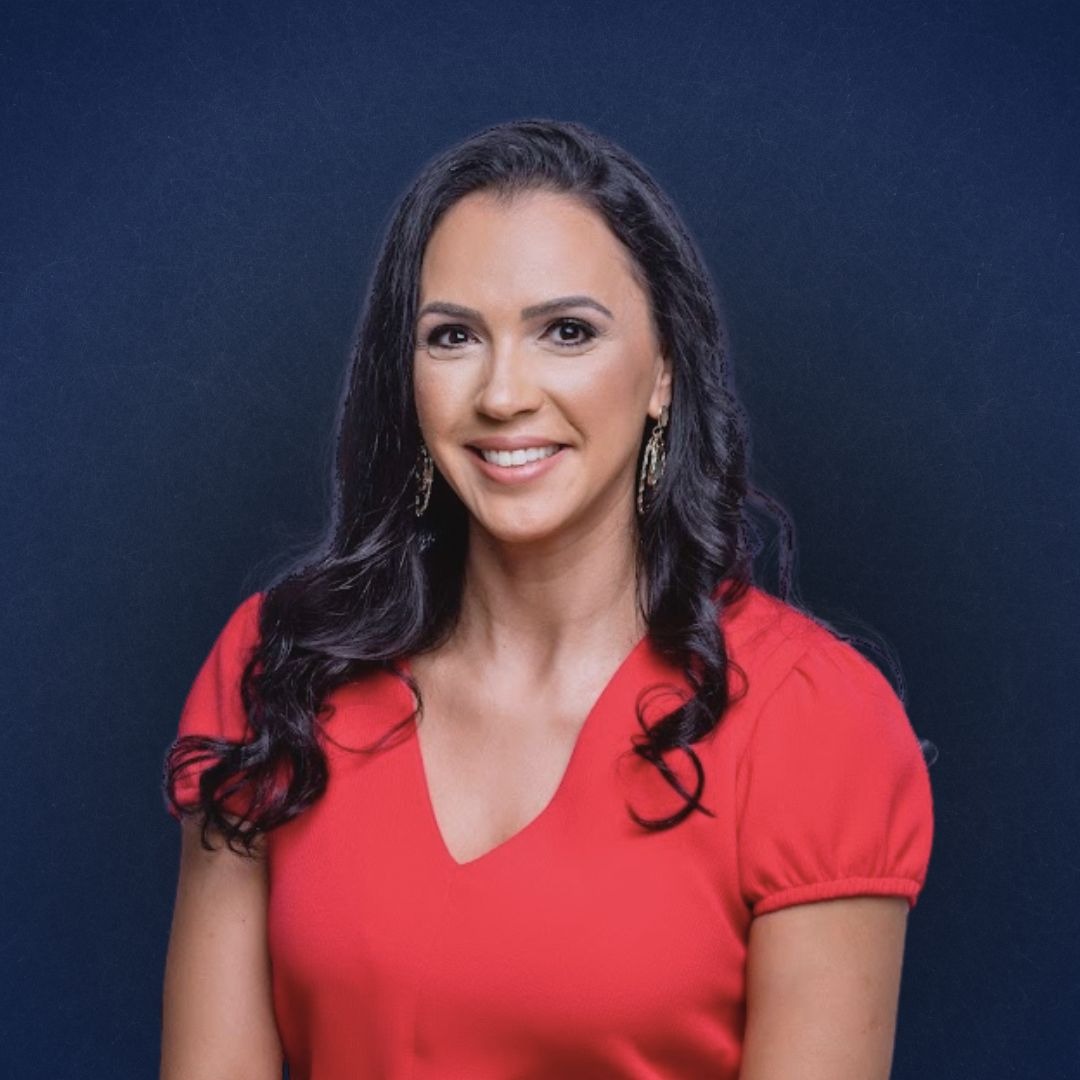 a woman in a red dress smiling at the camera
