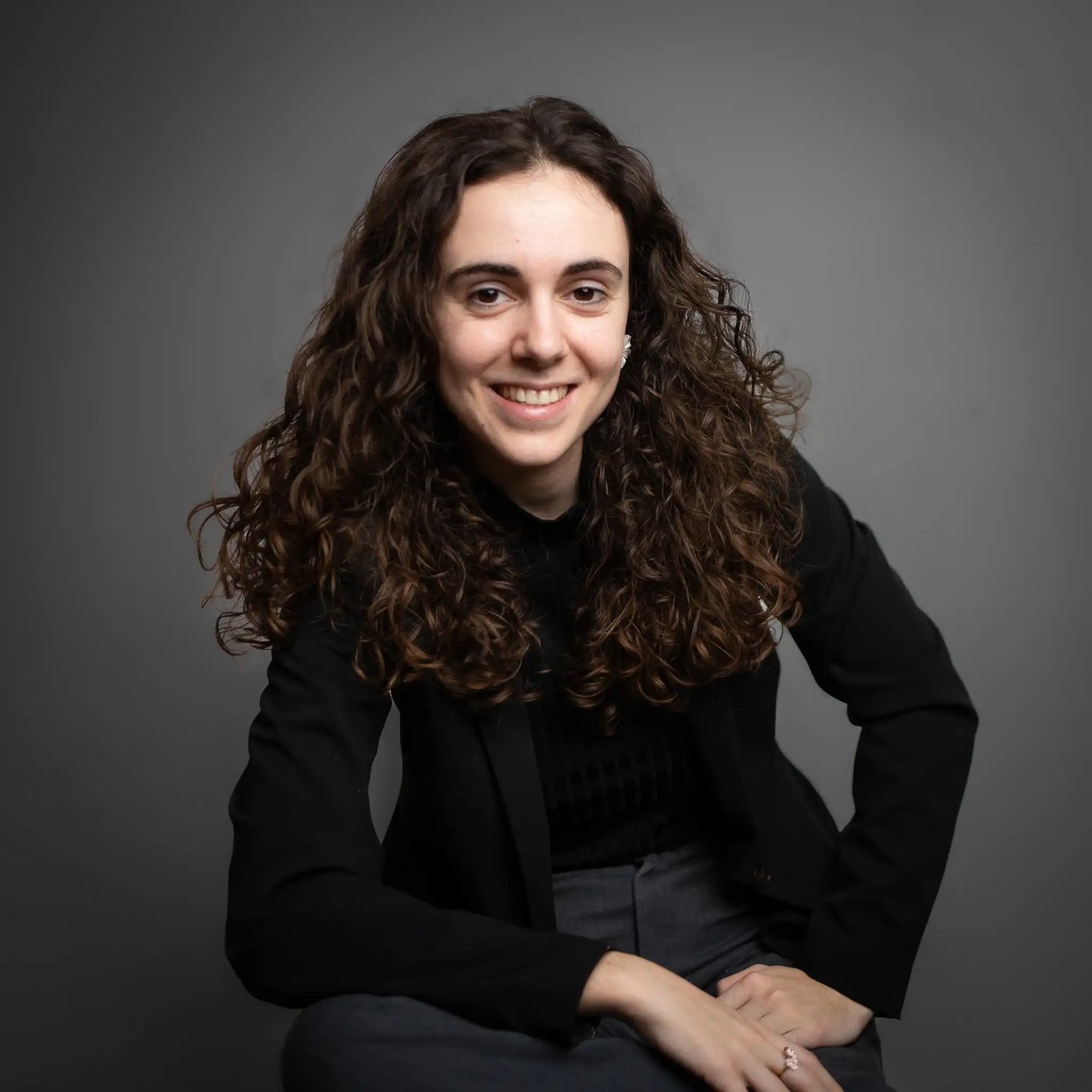 a woman with curly hair and a black jacket