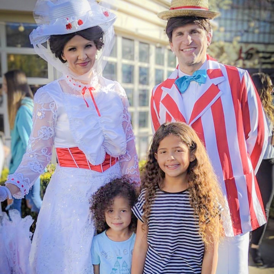 A Chimney Sweep character in a striped barbershop quartet jacket smiles for photo with child.