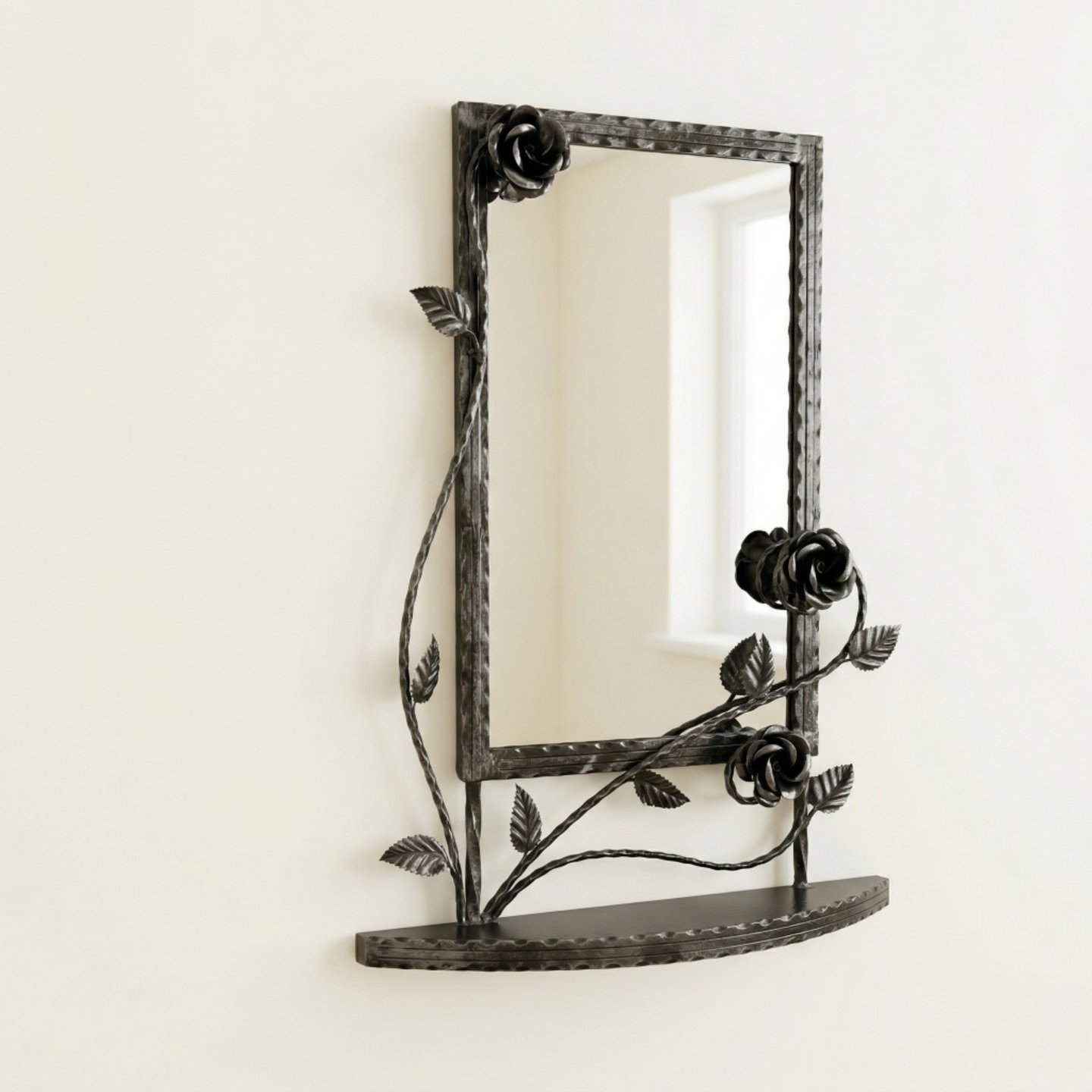 Ornate hand-forged wrought iron wall mirror with black rose vines and a built-in metal shelf.