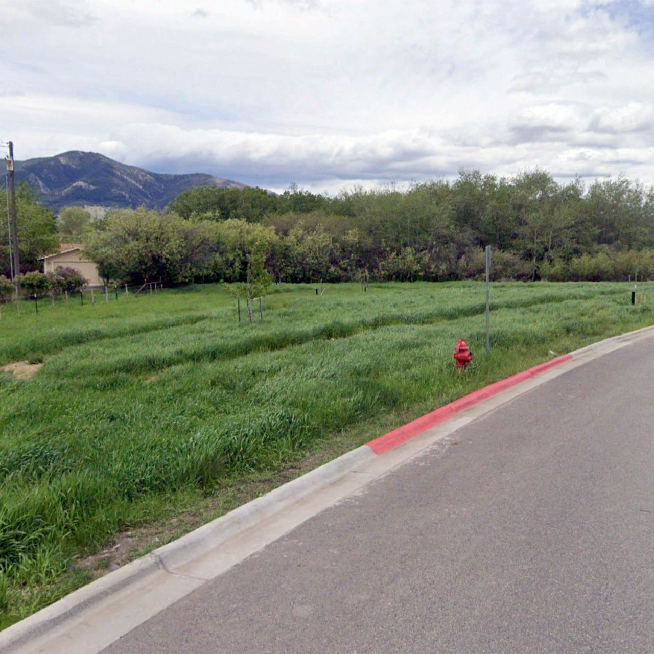 a red fire hydrant sitting on the side of a road