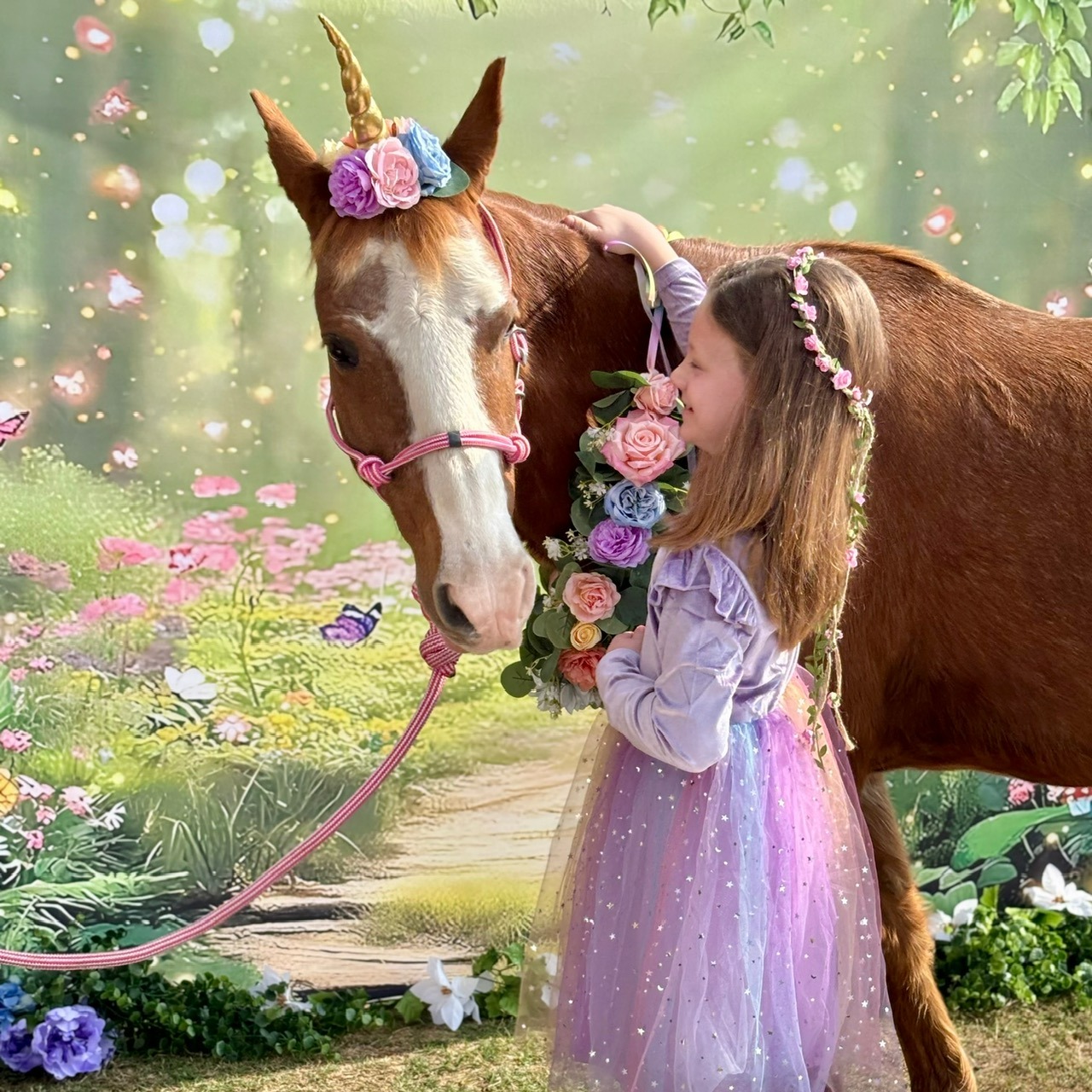 Princess smiling while cuddling Snickers the unicorn at a pony photo session